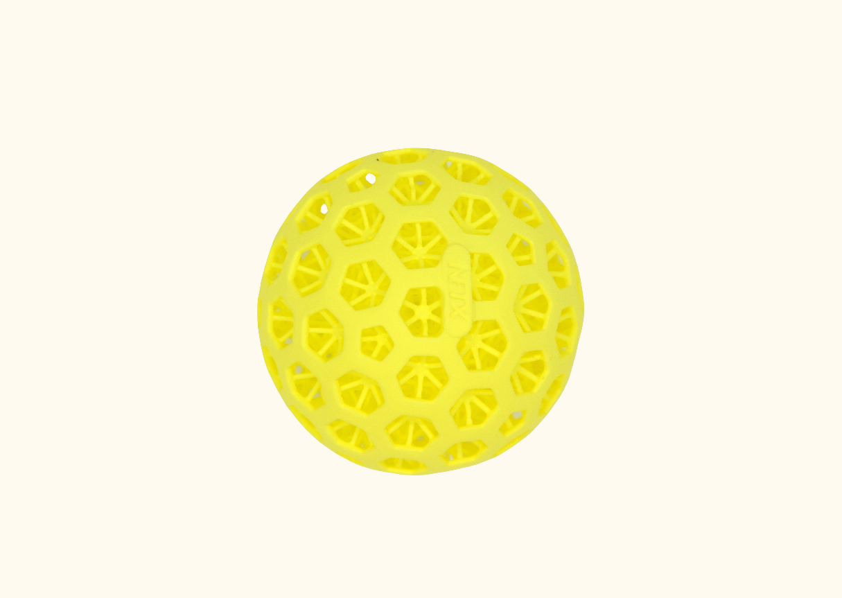 A yellow 3D printed pickleball with a distinctive pattern of holes on a white background.