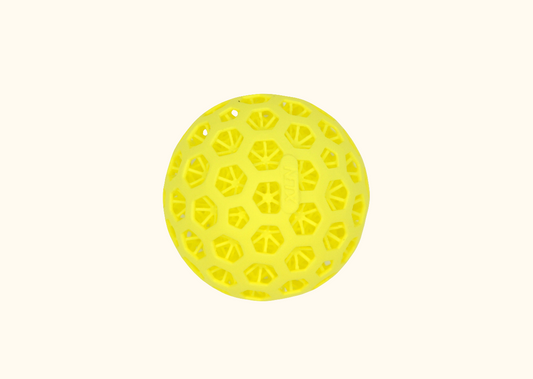 A yellow 3D printed pickleball with a distinctive pattern of holes on a white background.